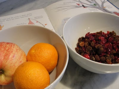 bowls of dried cranberries and apples and oranges