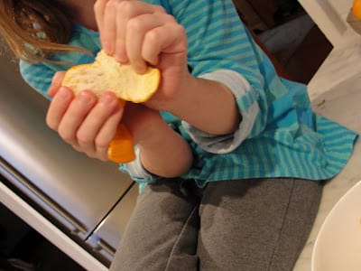 child peeling an orange