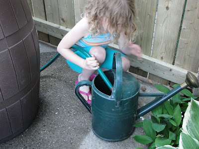 child operating a rain barrel