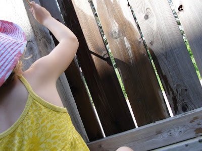 using water to paint a fence with child