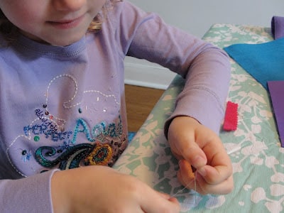 child threading a needle