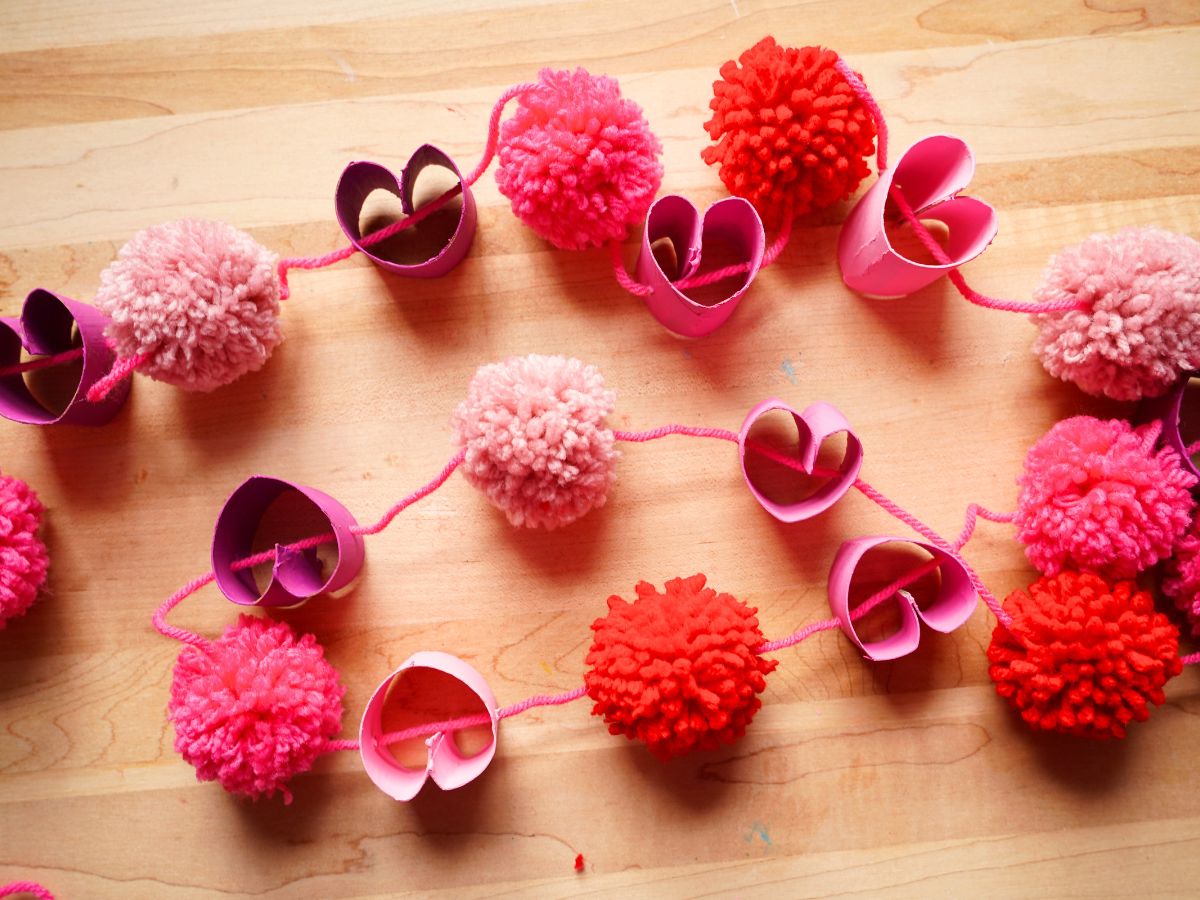 overhead shot of toilet paper roll and pom pom garland