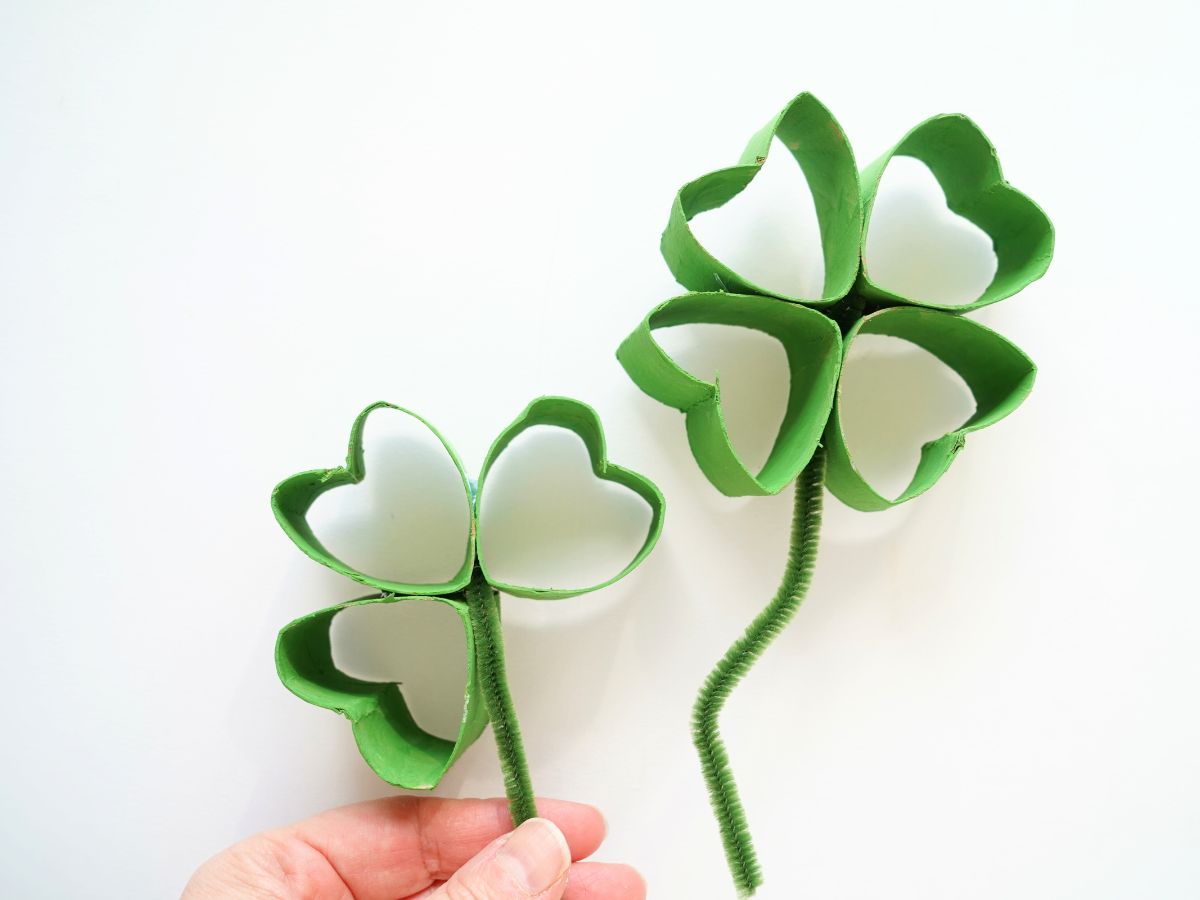 toilet paper roll four leaf clover with pipe cleaners stem in person's hand