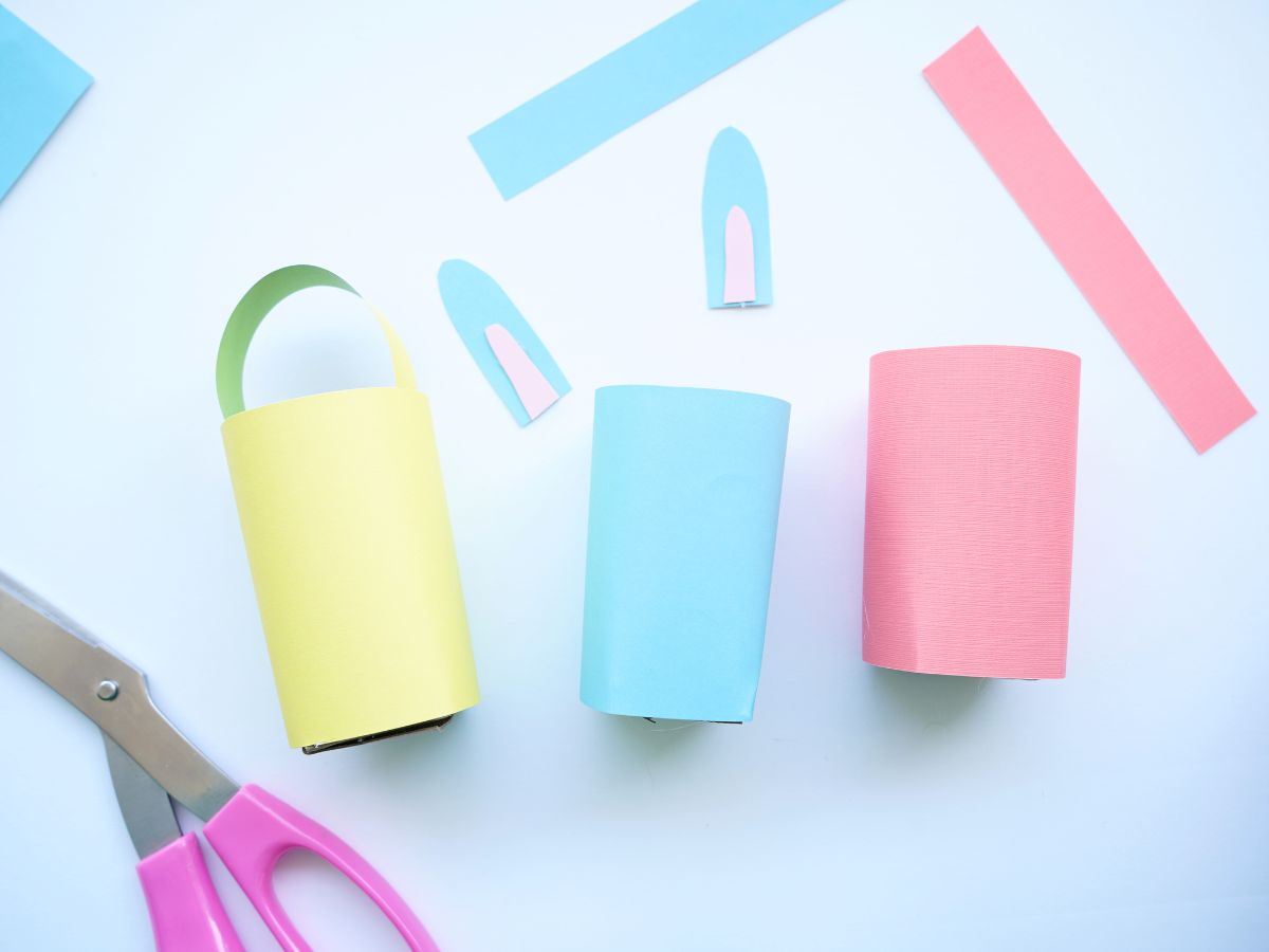 blue bunny ears with pink insides with easter baskets made from toilet paper rolls