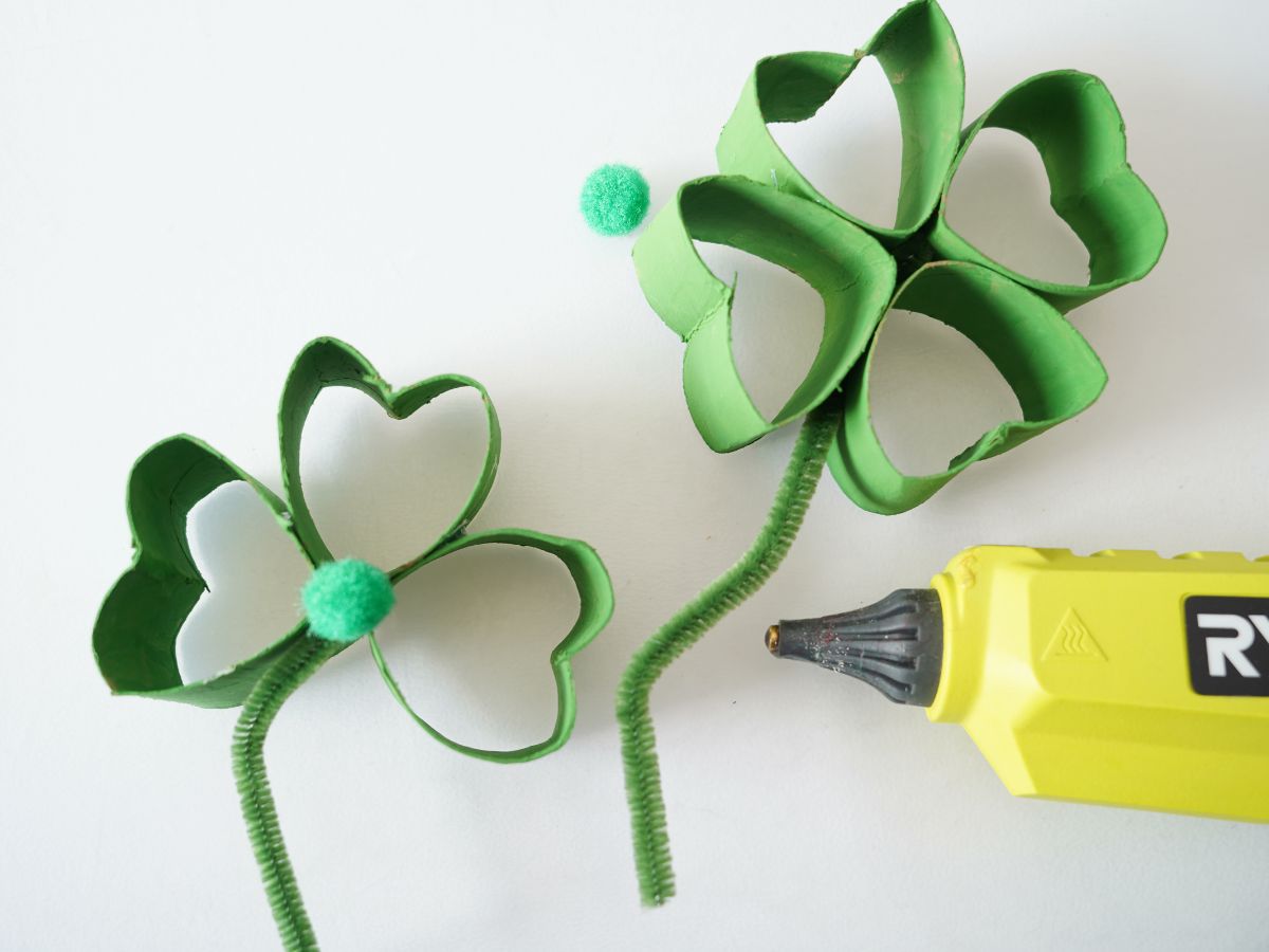 green pompoms being glued to the centre of the shamrocks