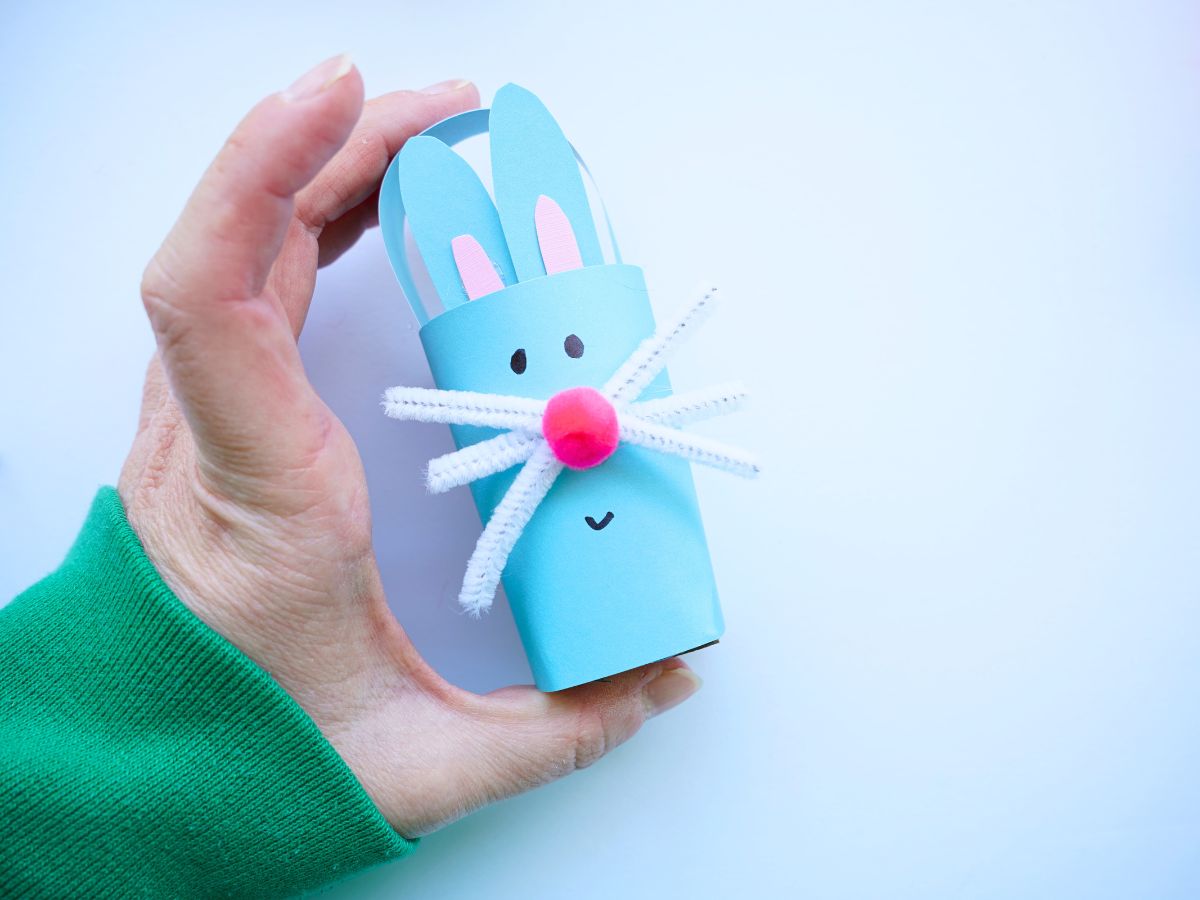 hand holding a finished toilet paper roll easter bunny basket with pompom nose