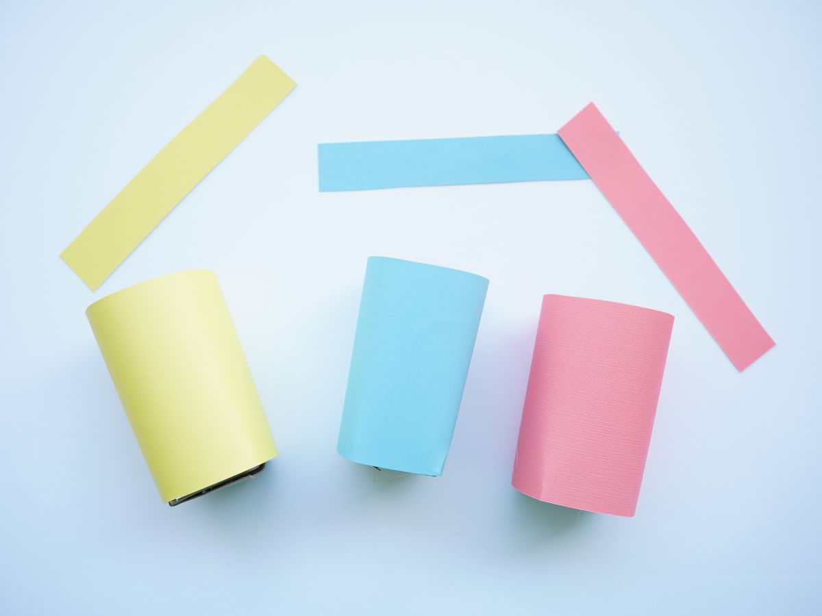 pink, blue, and yellow card stock wrapped and glued around toilet paper roll baskets with coordinating strips of paper