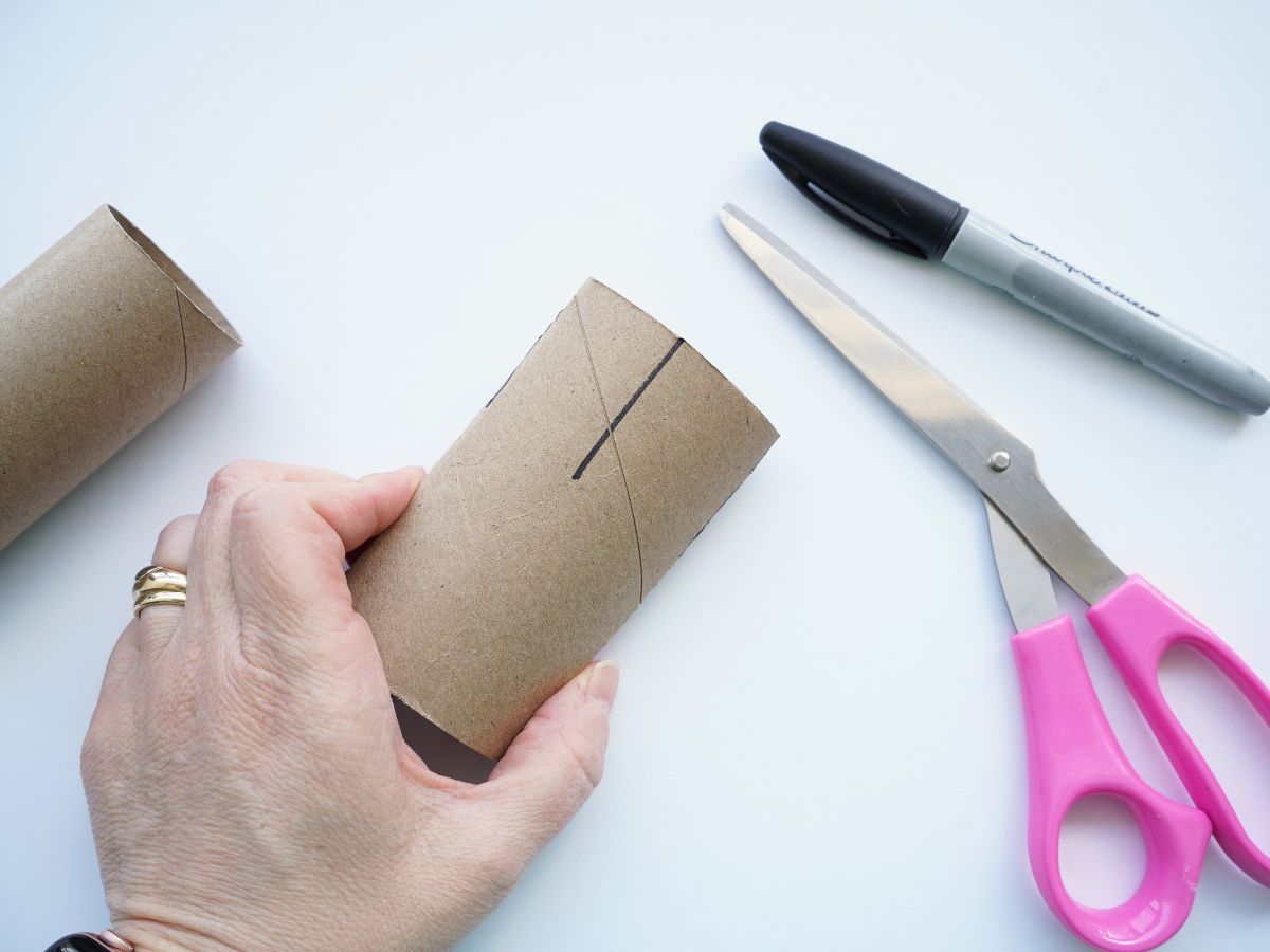 toilet paper roll with lines drawn on to cut and making the bottom of the basket